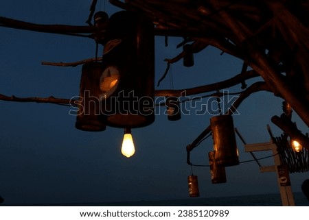 Photo of a unique lamp attached to a dry tree