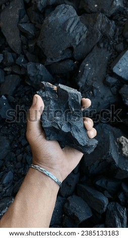 Coal mining: coal miner in the man hands of coal background. Picture idea about coal mining or energy source, environment protection. Industrial coals. Volcanic rock.