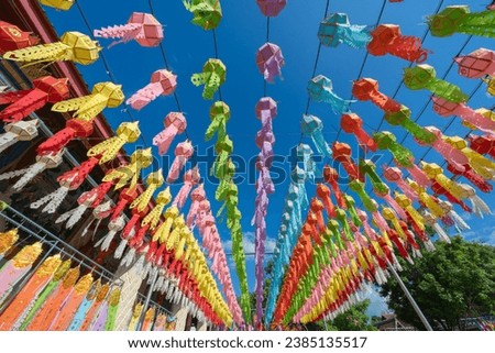 Lantern Festival or Yi Peng Festival in Hundred Thousand Lantern with the pretty Asian girl wearing a beautiful Thai traditional dress Lanna style Phra That Hariphunchai temple Lamphun, Thailand. Royalty-Free Stock Photo #2385135517
