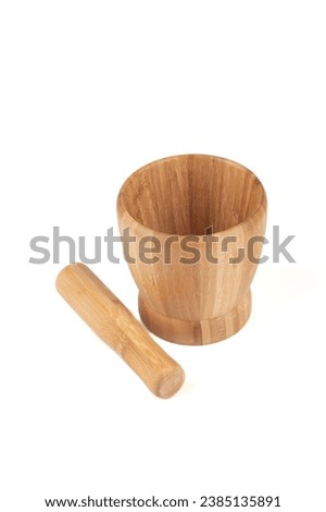 Wooden mortar and wooden pestle for grinding spices, isolated on a white background. Copy space. Royalty-Free Stock Photo #2385135891