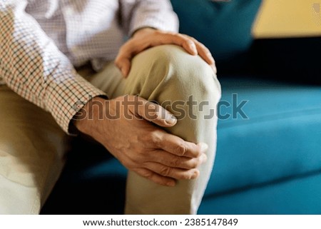 A Mature Man Massaging His Painful Knee. Man Suffering From Knee Pain At Home, Closeup. Pain Knee Royalty-Free Stock Photo #2385147849