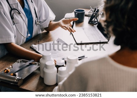 Smiling female doctor talking with senior patient in clinic office