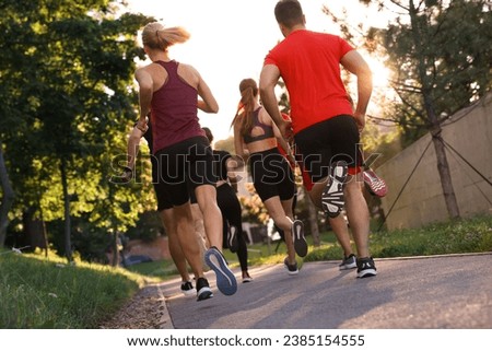 Group of people running outdoors, back view Royalty-Free Stock Photo #2385154555