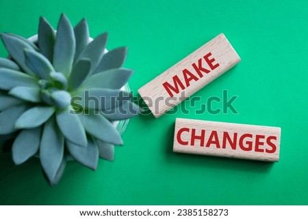 Make changes symbol. Wooden blocks with words Make changes with succulent plant. Beautiful green background. Business and Make changes concept. Copy space.