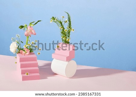 Wooden platforms are randomly arranged with fresh flowers on a blue-pink background. Space for text and image design-for bouquets, wedding invitations, anniversary, birthday, postcards, greetings.