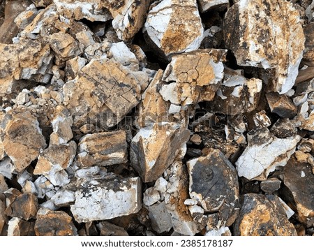 Part of a pile of stones for construction and stones piled up, close up. Brown Granite. Large pile of limestone in the quarry. Pile of gravel and construction materials