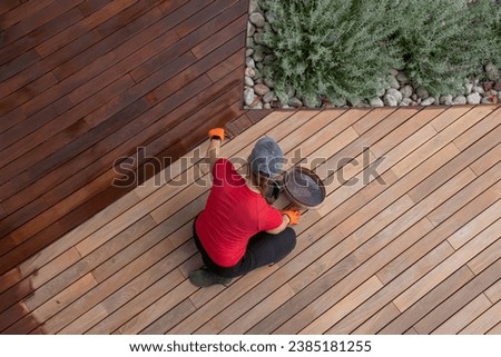 Refreshing of wood deck boards with UV protection pigment oil Royalty-Free Stock Photo #2385181255