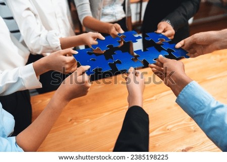 Multiethnic business people holding jigsaw pieces and merge them together as effective solution solving teamwork, shared vision and common goal combining diverse talent. Meticulous Royalty-Free Stock Photo #2385198225