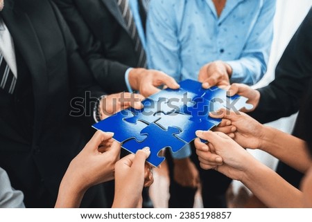 Multiethnic business people holding jigsaw pieces and merge them together as effective solution solving teamwork, shared vision and common goal combining diverse talent. Meticulous Royalty-Free Stock Photo #2385198857