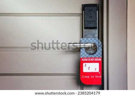 Closed door of hotel room with please do not disturb sign hang on door knob
