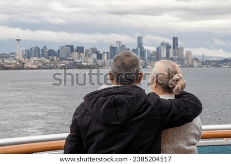 Couple gazing at Seattle skyline from cruise ship on Puget Sound - Seattle, Washington, USA