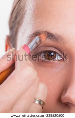 Makeup artist paints the eyebrows model. painting of eyebrows