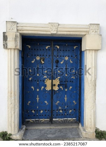 magnificent greek style blue wooden closed door with marble on both side on white wall building greece cyprus Royalty-Free Stock Photo #2385217087