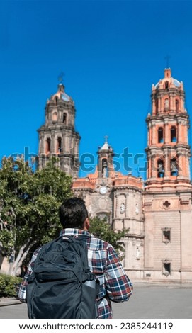 Male tourist in a mexican colonial town looking at the cathedral, daylight, copy space