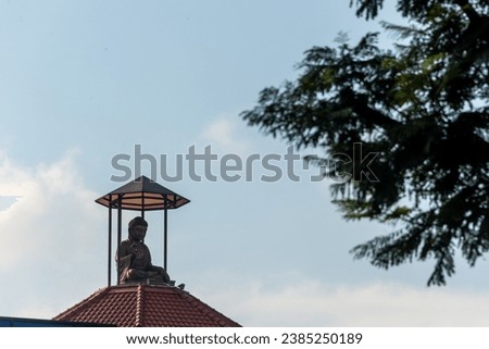 Buddha on roof in blue sky .