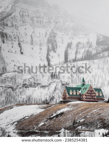 Nestled at the edge of the iconic Waterton Lakes National Park in Alberta, Canada, the Prince of Wales Hotel reigns supreme as a picturesque landmark overlooking the pristine Waterton Lake.  Royalty-Free Stock Photo #2385254381