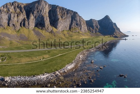 Drone image of Værøy island in Lofoten. Amazing small island at the top of Lofoten. Perfect calm sunny summer day. Birds eye view of an amazing island. Massive cliffs just by the ocean