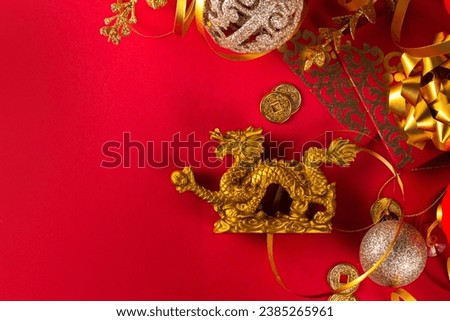 Chinese New Year 2024 greeting card. Bright red asian year of the dragon background with golden dragon figurine, Chinese lanterns, traditional jewelry, gifts, coins, cookies with wishes, copy space