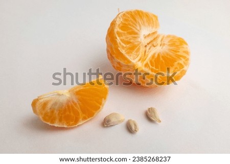 Wedges tangerine and seeds on white background, close-up. Citrus composition for publication, poster, calendar, post, screensaver, wallpaper, postcard, banner, cover, website. High quality photography