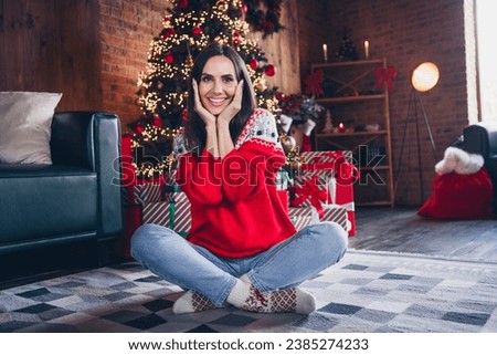 Photo of pretty gorgeous girl dressed red print jumper sitting fluffy carpet rejoicing magic winter season room indoors