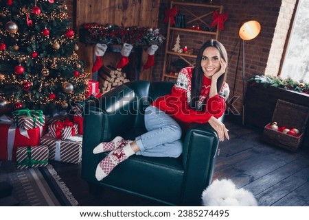 Photo portrait of pretty brunette young girl sit soft armchair enjoy comfort wear ornament sweater beautiful living room decor christmas