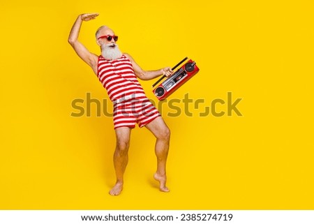 Full size photo of aged man happy having fun listen music boombox dance showing empty space nightclub isolated on yellow color background