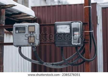 Electricity measuring meter outside street winter house. Display with numbers kWh counter. Power box for home use. Energy savings monitoring equipment or over consumption, rising prices and costs
