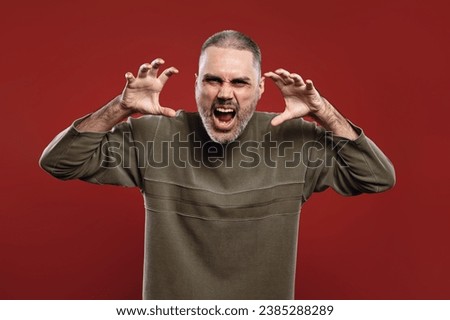 man with his mouth open and his hands close to his face as if he were going to attack