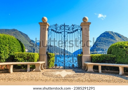 Old wrought iron gate overlooking Lake Lugano in Ciani Park, Lugano, Switzerland Royalty-Free Stock Photo #2385291291