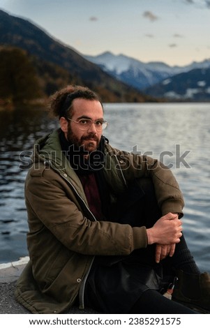concept of beauty outside the canons. young adult man faces a portrait. Elegant 30-year-old guy with a landscape background of mountains and lakes. Attractive male model. Modern millennial people. b