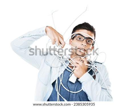 Portrait of man in glasses tangled in wire, cables and isolated on a white background. Face of serious geek wrapped in cord and tech of nerd or electrician, mistake and problem, chaos or struggle Royalty-Free Stock Photo #2385305935