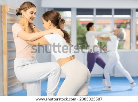 Self-defense class - woman practices blows to the head of an attacking woman