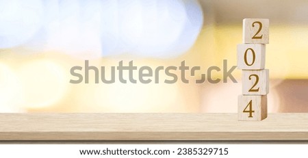 Happy New Year 2024 on wood cube block and blur abstract bokeh light with copy space background, Happy new year 2024 greeting card, banner