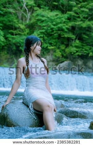 Beautiful girl enjoying a picnic taking photos and posing with Bikini by the stream.