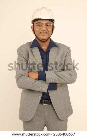 Portrait of Confident smart male  engineer in white hardhat over formal suit and looking at camera while isolated on studio background Royalty-Free Stock Photo #2385400657
