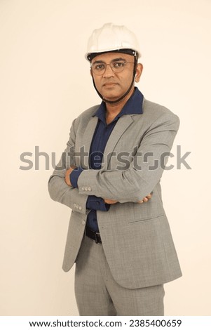 Portrait of Confident smart male  engineer in white hardhat over formal suit and looking at camera while isolated on studio background Royalty-Free Stock Photo #2385400659