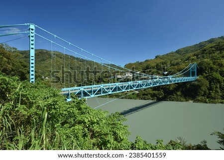 A colorful and beautiful steel structure bridge and a red arch bridge over the stream.