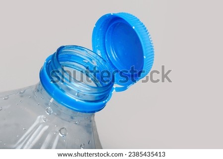 Close up of new cap attached to plastic bottle, connected to the neck of the bottle by solid tab attached to safety ring. They are intended to encourage recycling, as part of the fight against litter. Royalty-Free Stock Photo #2385435413