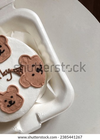 Bento cake for celebration day. A small cake with a picture or a congratulation for one person. A funny surprise dessert for a loved one. Cake with the head teddy bear.