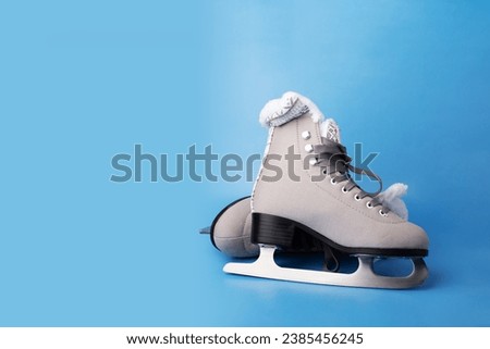 Ice skate boots on a blue background, a winter sport symbol, copy space Royalty-Free Stock Photo #2385456245