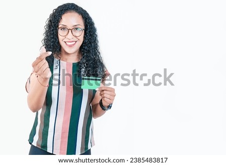 Happy afro girl in glasses holding credit card making money gesture with fingers, looking at camera isolated Royalty-Free Stock Photo #2385483817