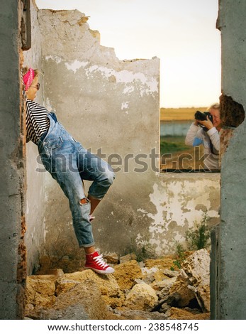 photographing girls on a construction site in denim overalls and sneakers