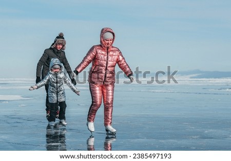 The sport family is skating on the ice of Lake Baikal. Winter Siberian landscape
