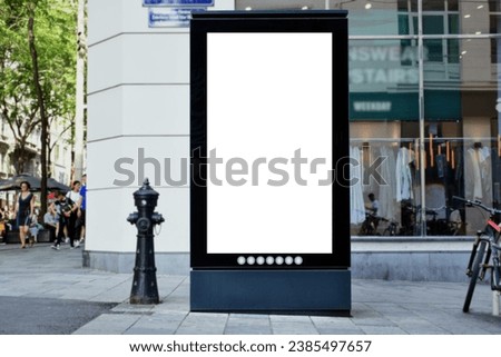 blank white poster and advertiser ad space. digital outdoor display lightbox and billboard. street corner. mockup base. empty display panel. glass design. soft streetscape. shopping street background