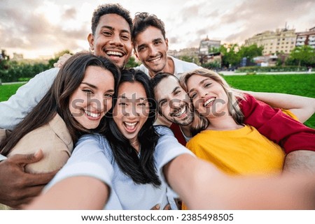 Multiracial friends smiling at camera outdoors - Happy group of young people taking selfie picture with smart mobile phone device - Friendship concept with guys and girls hanging outside