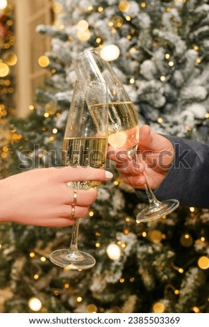 Two glasses of champagne in the hands of a man and a woman, close-up. New Year concept.