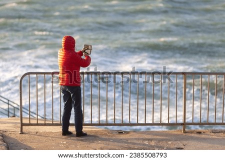 woman on a pier taking pictures from cell phone.
