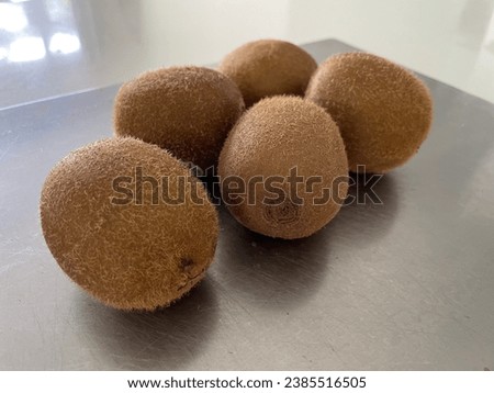 Fresh new-zealand kiwi fruits by group of five together on a metallic counter top or work top