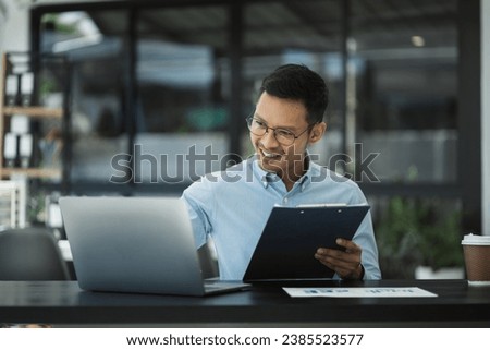 Businessman using laptop computer in office. Happy man, entrepreneur, small business owner working online.