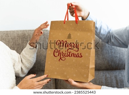 Close-up of a man giving a christmas gift to a woman at home.
Christmas gifts concept.